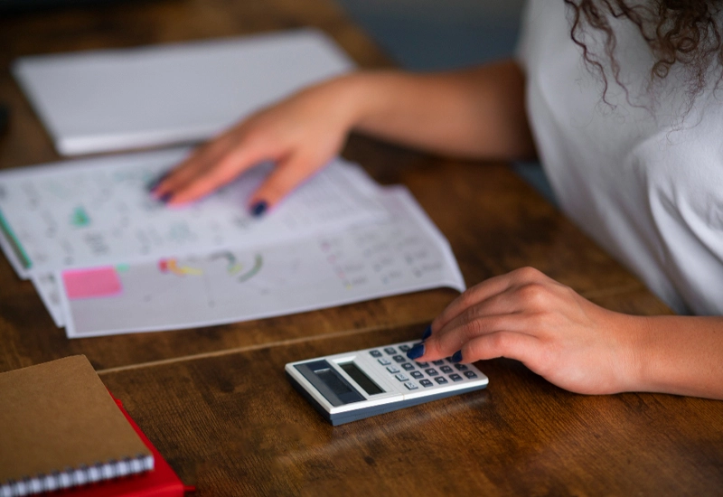 Mujer echando cuentas con una calculadora